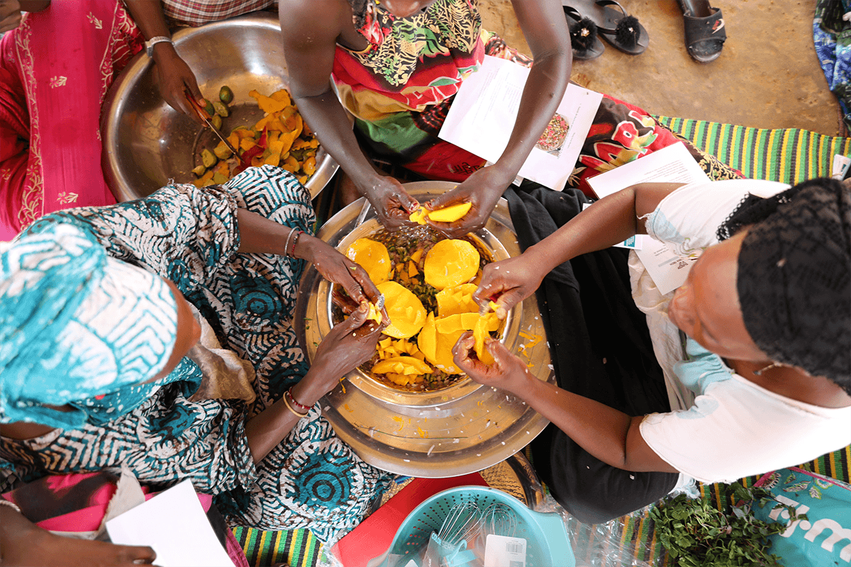 Overhead shot of villagers preparing to cook stew